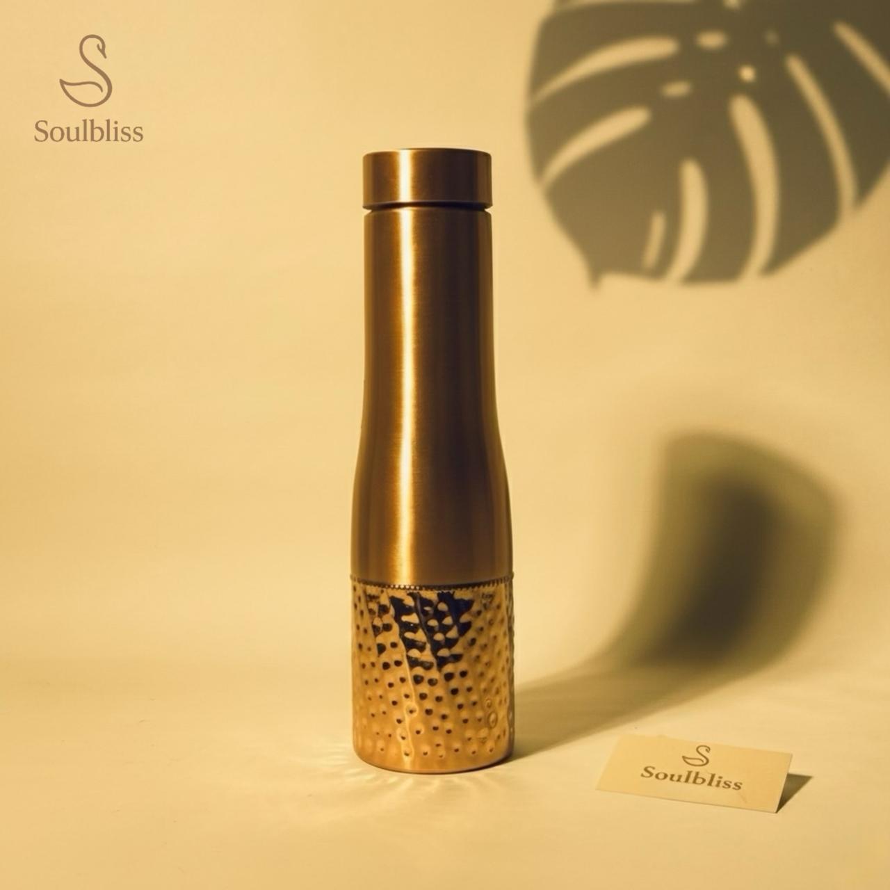 copper water bottle with textured design on a beige background, featuring the brand 'Soulbliss'.