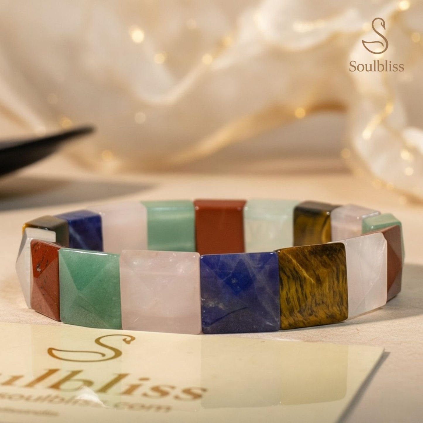 Multicolored stone bracelet on a white surface with 'Soulbliss' branding.