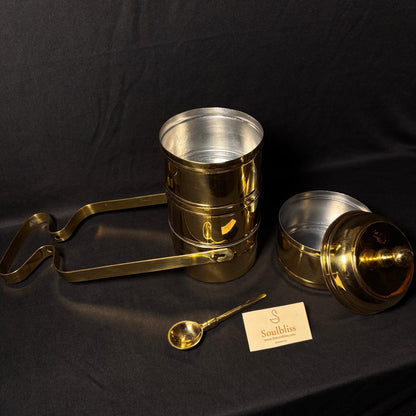 Gold and  brass tiffin set with a spoon on a black background
