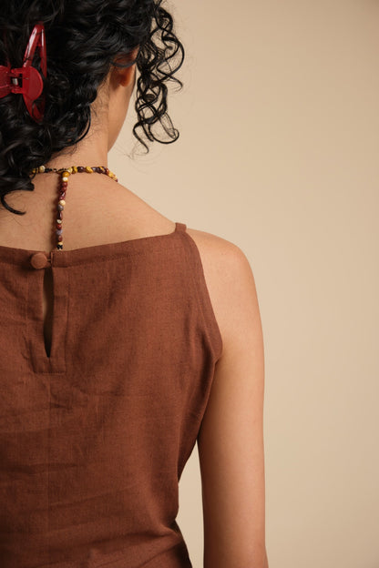 Brown sleeveless top worn by a person with a neutral background