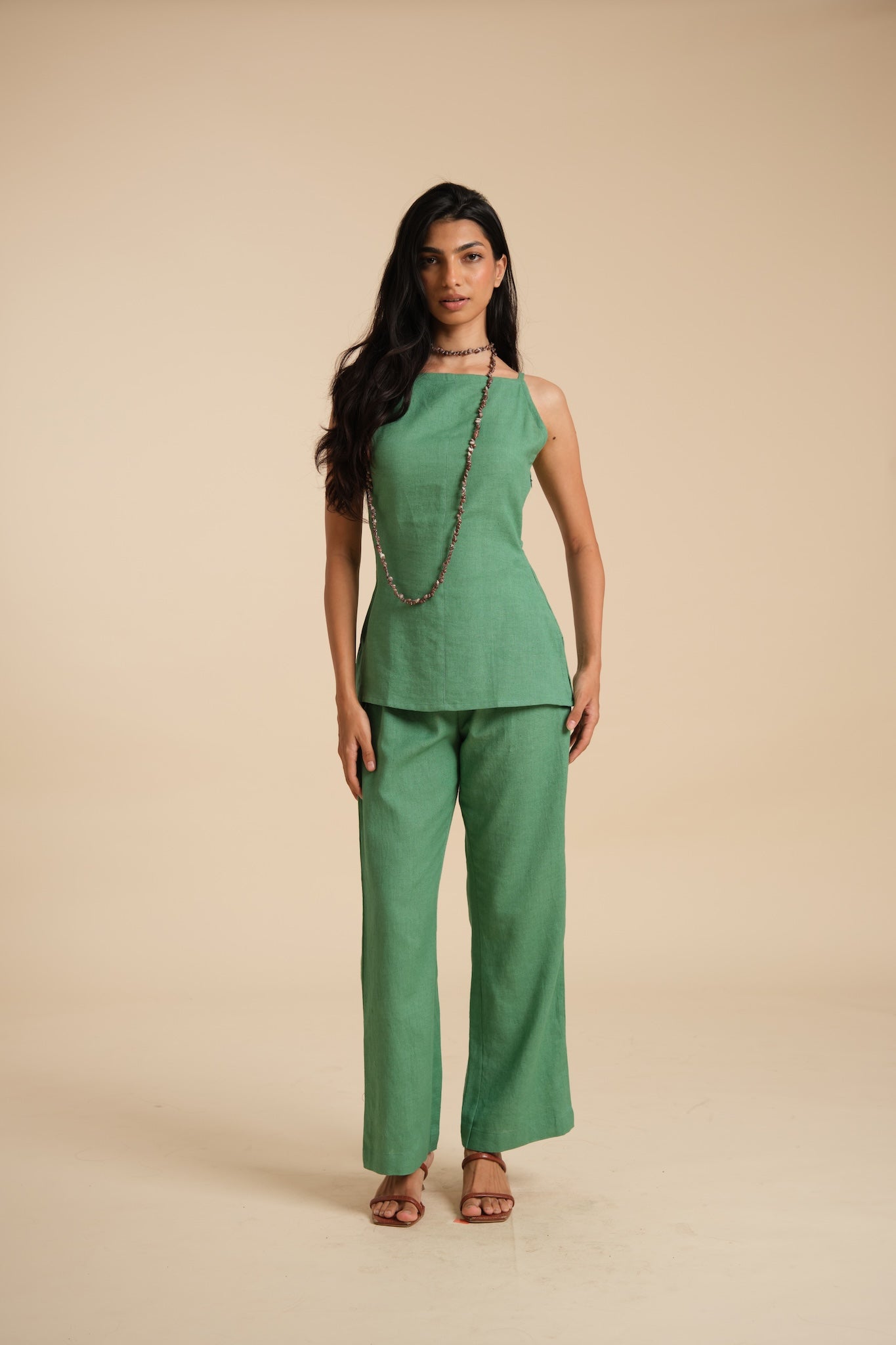 Woman wearing a green outfit on a beige background