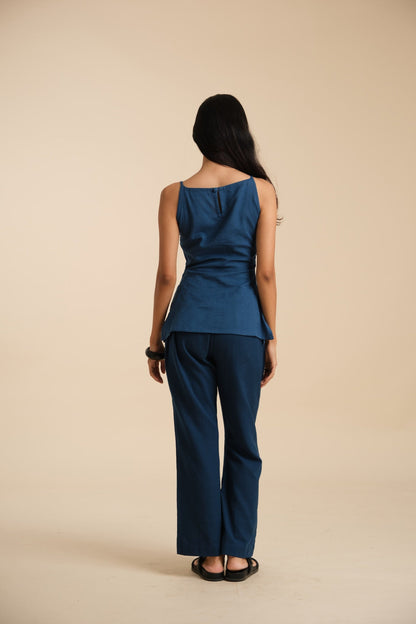 Woman wearing a blue outfit standing against a beige background