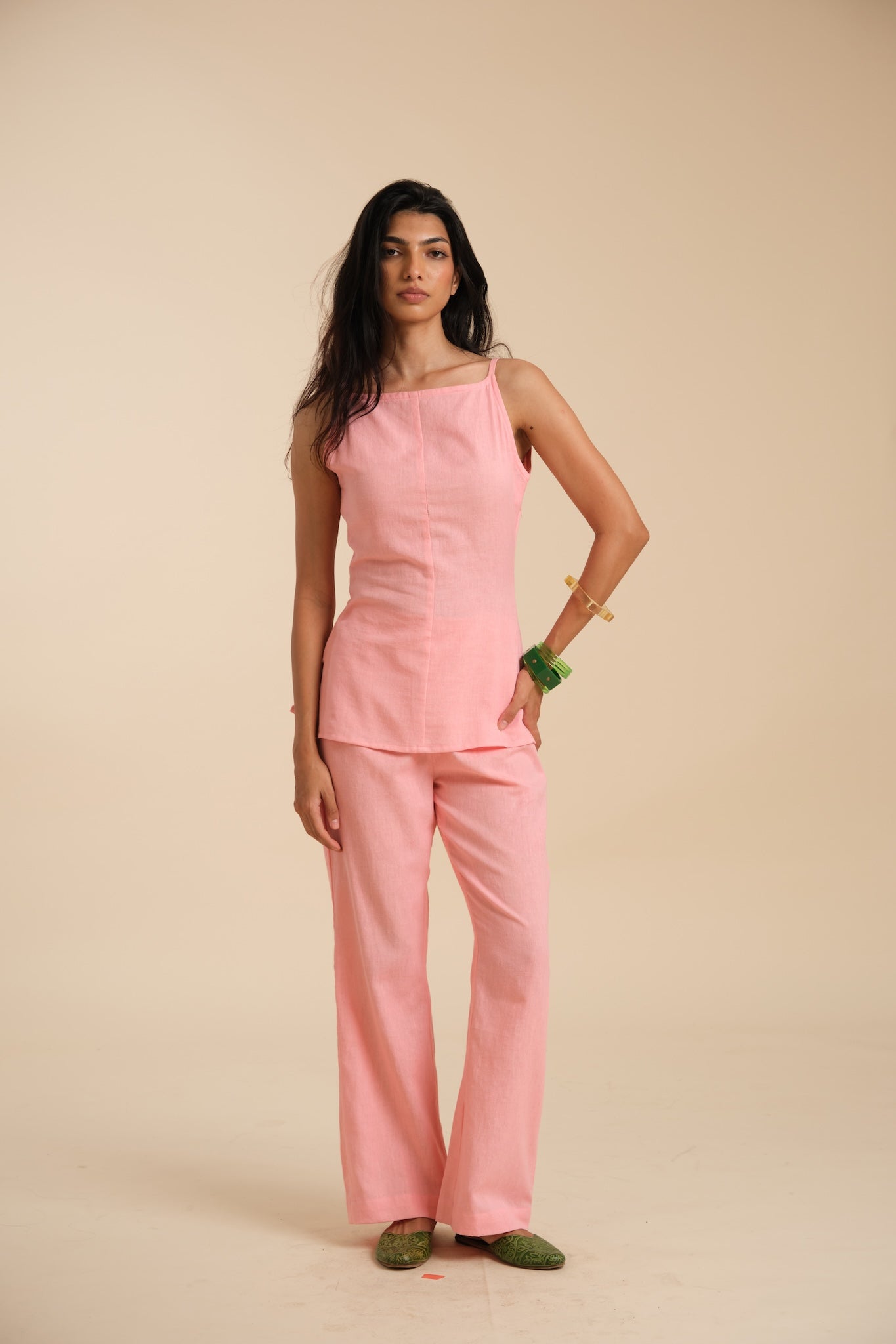 Woman wearing a pink outfit on a beige background