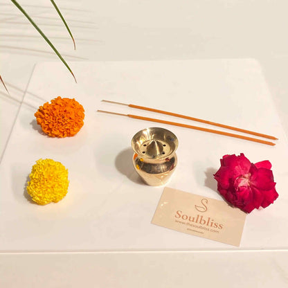 Decorative items including a gold incense burner, flowers, and incense sticks on a white surface with 'Soulbliss' branding.