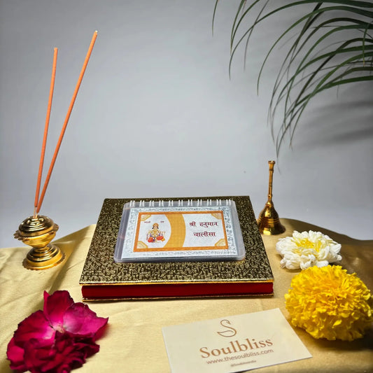 Decorative setup with incense sticks, flowers, and a card on a table with a gray background.