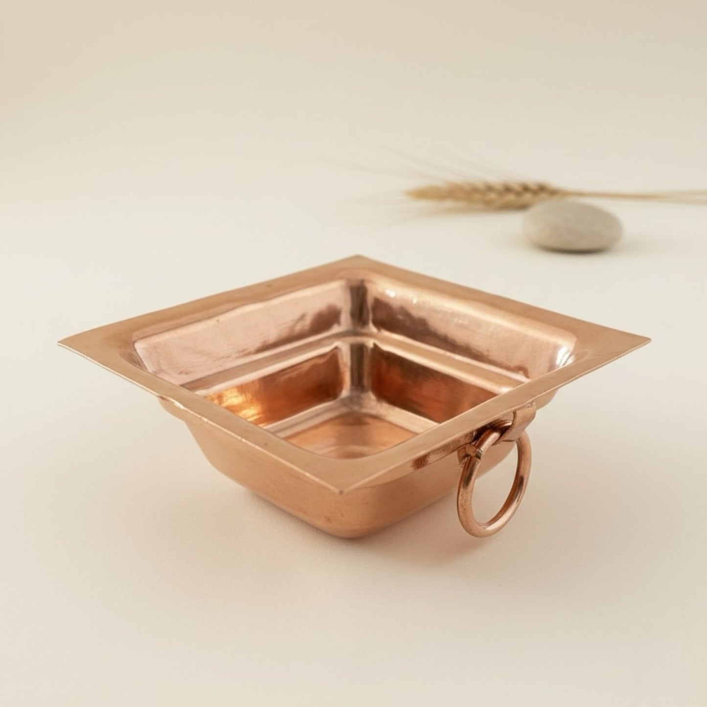 Copper havan kund with ring holder on a light background