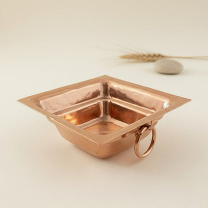 Copper havan kund with ring holder on a light background
