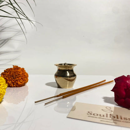 Scented candles, incense sticks, and flowers on a white surface with 'soulbliss' branding.