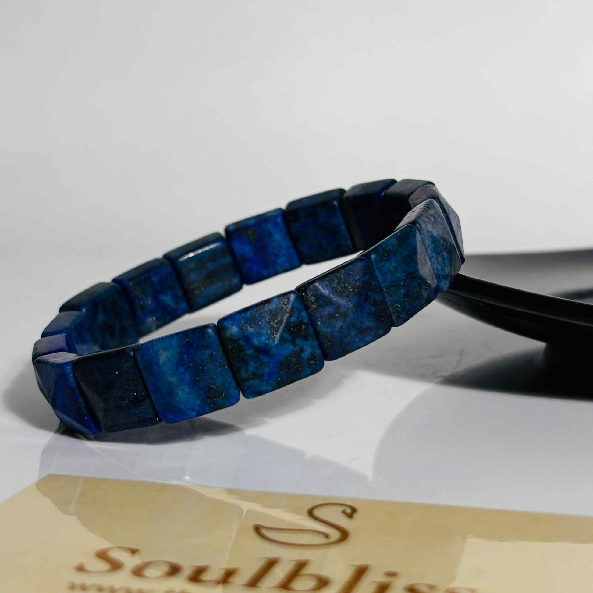 Blue beaded bracelet on a white surface with 'Soulbliss' branding.