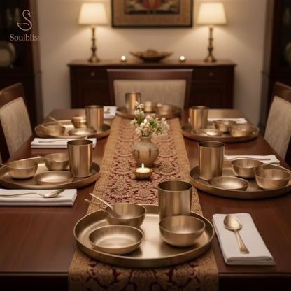 Dining table set with metallic dishes and a patterned runner, featuring the brand 'Soulbliss'.