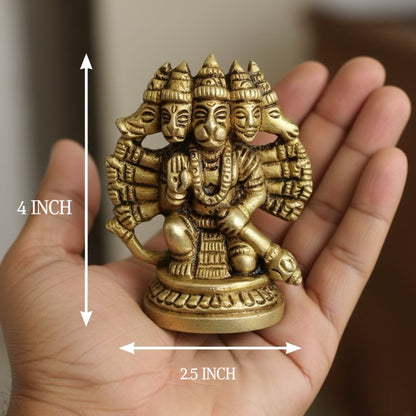 Small gold-colored statue of hanumanji held in a hand with measurements indicated