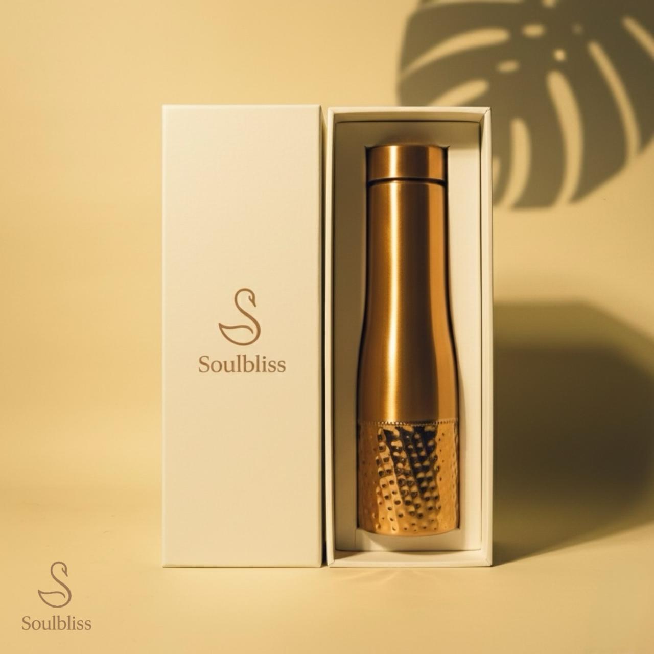 Gold textured bottle in a 'Soulbliss' box on a beige background