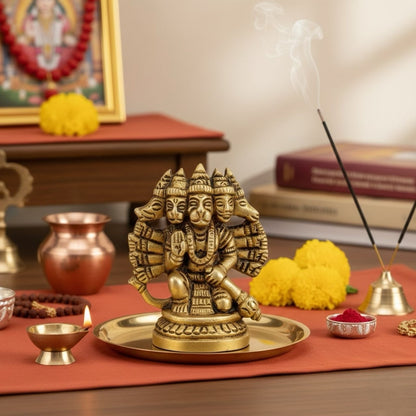 brass statue of panchmukhi hanumanji with incense sticks and flowers on a table